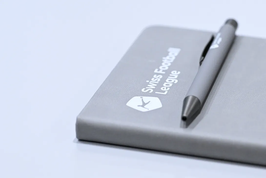 Symbolbild: Ein Foto eines Notizblocks mit dem Logo der Swiss Football League. Ein Kugelschreiber ist auf den Notizblock gelegt.
